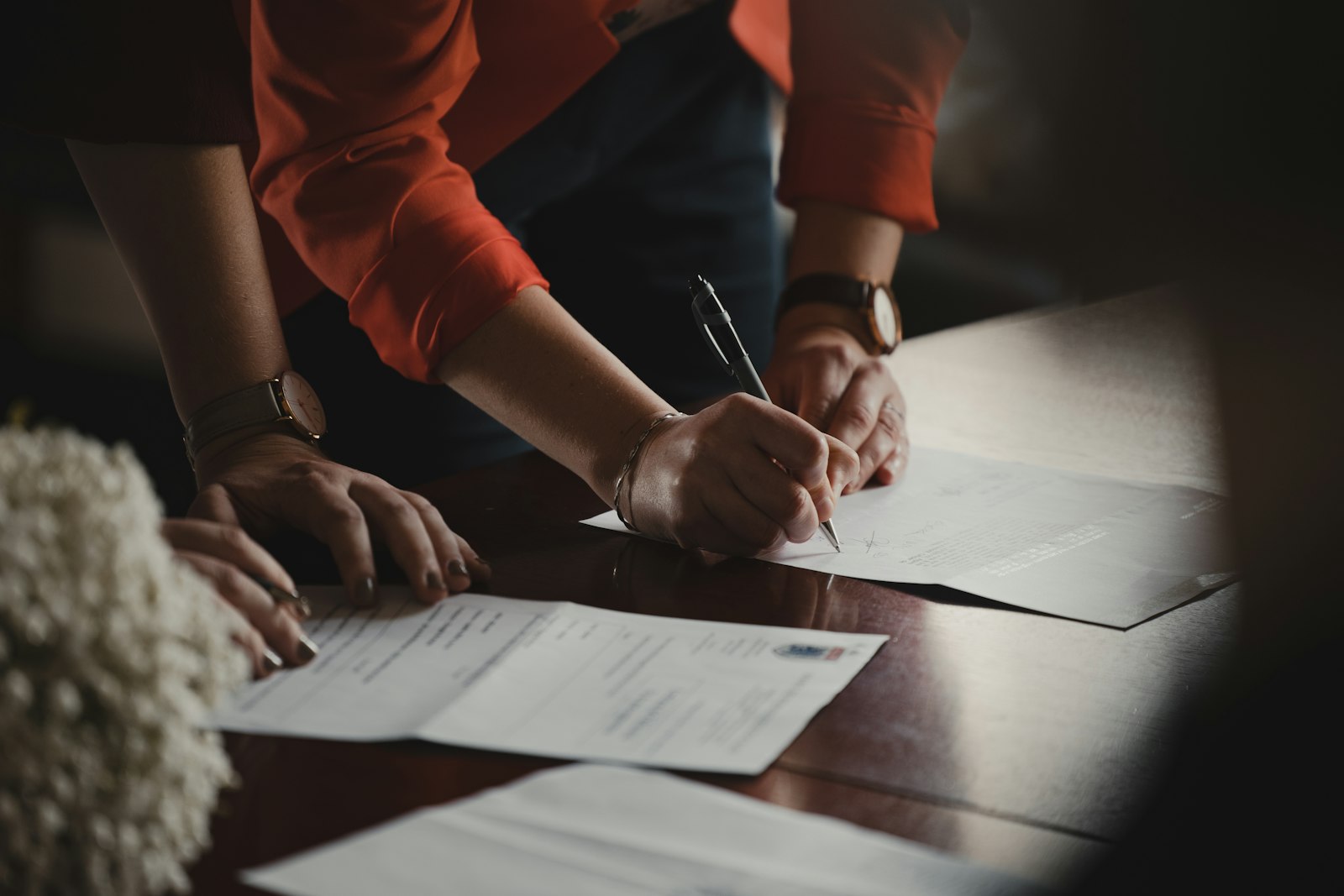 Pessoas assinando documentos sobre uma mesa